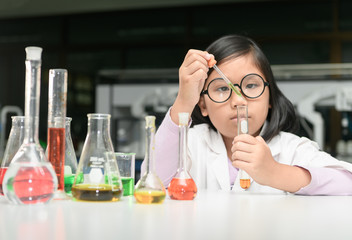 Wall Mural - little scientist in lab coat making experiment