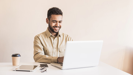 young handsome man using laptop in office. businessman or student working on computer online. freela