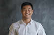 © mavoimages - Content Asian businessman standing in front of a blank chalkboard
