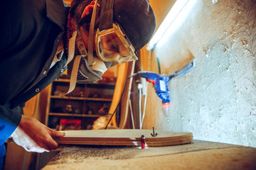 Wall Mural - Portrait of handsome carpenter working with wooden skate at workshop, profile view