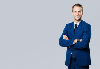 smiling young businessman, on grey