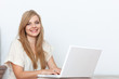 © gallofilm - Young woman using a notebook computer indoors