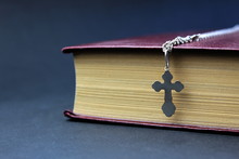 Orthodox Cross And Bible In Burgundy Binding On A Black Background