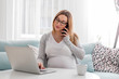 © leszekglasner - Pregnant woman working online with laptop at home, freelancing concept