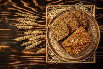 Home made organic goji berry Bread with seeds and ears wooden background close up. healthy food concept