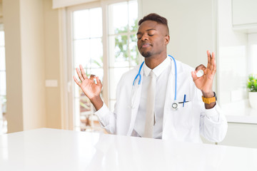 Canvas Print - African american doctor man at the clinic relax and smiling with eyes closed doing meditation gesture with fingers. Yoga concept.