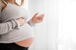 © leszekglasner - Health during pregnancy, Pregnant woman drinking water sitting on sofa