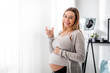 © leszekglasner - Health during pregnancy, Pregnant woman drinking water sitting on sofa