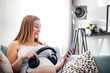 © leszekglasner - Beautiful cheerful pregnant woman holding headphones on belly showing music to baby