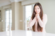 © Krakenimages.com - Beautiful Asian woman wearing casual sweater on white table shouting and suffocate because painful strangle. Health problem. Asphyxiate and suicide concept.
