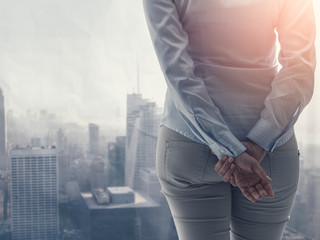 Wall Mural - Young businesswoman standing next to a window and cityscape view