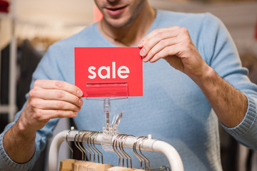 Wall Mural - Seller holds red signs with sale word