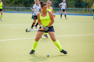 Young hockey player woman with ball in attack