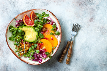 Wall Mural - Vegan, detox Buddha bowl with turmeric roasted  chickpeas, greens, avocado, persimmon, blood orange, nuts and pomegranate. Top view, flat lay, copy space