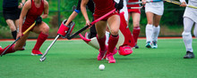 Field Hockey Players Challenge Eachother For Possession Of The Ball On The Midfield Battle Of A Hockey Mach