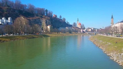 Sticker - Observe the wide Salzach river with parks, stretching along Kaipromenade and Elisabethkai embankments and the tall belfries of Mullner Church and Protestant Parish Christ Church, Salzburg, Austria.