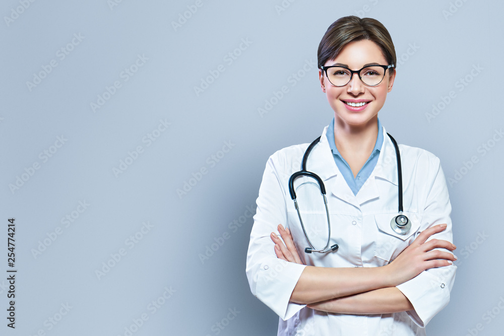 Portrait of glad smiling doctor in white uniform standing with crossed ...