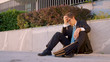 Sad businessman holds his head while sitting on the pavement after getting fired