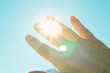Male hand covers the sun. The sun shines through the palm. Scorching sun. Background. Texture.