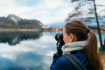 Wall Mural - Lady taking photos of Bled Lake and Church in Slovenia