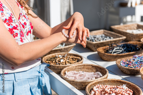 Cuadros en Lienzo Young woman shopping for colorful stone beach bead bracelets trying on jewelry i