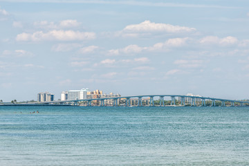 Sanibel Island, USA Bay during sunny day with toll bridge causeway bridge highway road and cars in traffic holiday vacation destination in Florida people swimming