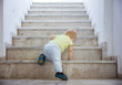 Baby girl crawling up stairs outdoors