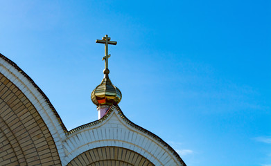 The domes of the Orthodox church against the blue sky, beautiful golden