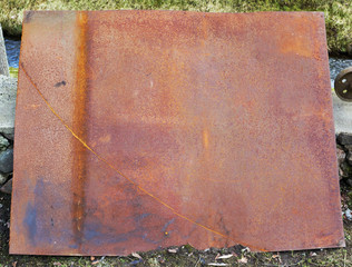 Wall Mural - Large rusty iron sheet on a rustic courtyard