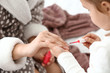 © Pixel-Shot - Cute daughter with mother making manicure at home