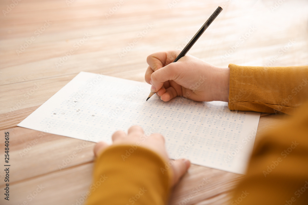 Girl passing school test in classroom, closeup