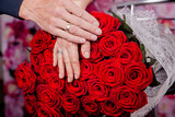 Fototapeta  - Duży bukiet czerwonych róż i dłonie zakochanej pary