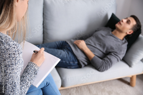 Fotografía Female psychologist working with patient lying on sofa in her office