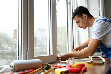 Poster - Young worker installing window in flat