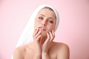 Wall Mural - Young woman with under-eye patches on color background