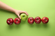 © Pixel-Shot - Female hand with tasty apples on color background. Concept of uniqueness