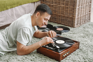 Canvas Print - Young man listening to music on record player at home