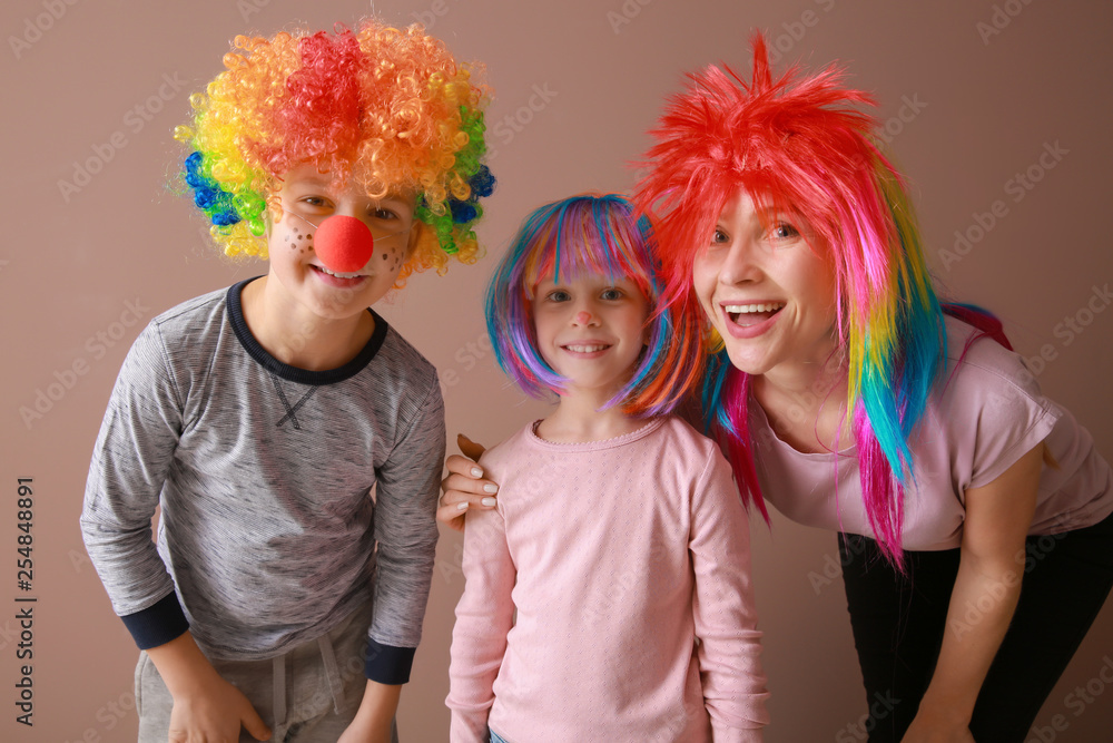 Family in funny disguise on color background. April fools' day celebration