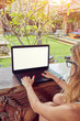 © astrosystem - Girl using laptop on a home porch / terrace.