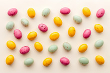 Easter Chocolate Eggs Candy On A Pastel Yellow Background, Creative Flat Lay Easter Concept, Top View