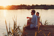 © djile - Young loving couple enjoys by the river during the sunset