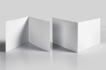 Blank folded booklets, postcards, flyers or brochures mockup template on gray background