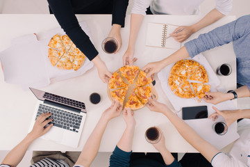 Business team is eating pizza at work while working