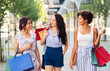 © Syda Productions - sale, consumerism and people concept - happy young women with shopping bags walking along city street