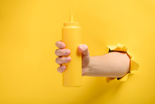 Hand Holding A Mustard Bottle
