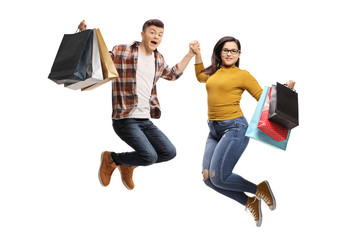 Wall Mural - Energetic male and female teenagers jumping with shopping bags