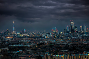 Fototapete - Panorama der beleuchteten Skyline von London am Abend mit Wolken und schlechtem Wetter: von der City bis zur Tower Brücke 