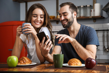 Wall Mural - Beautiful cheerful couple having breakfast