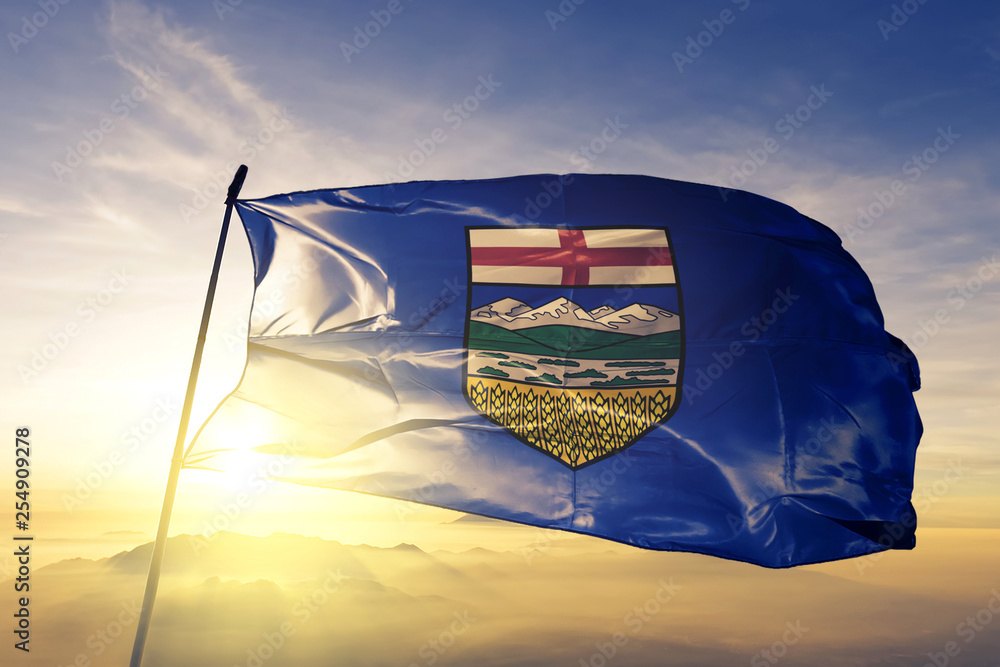 Alberta province of Canada flag waving on the top sunrise mist fog - obrazy, fototapety, plakaty 