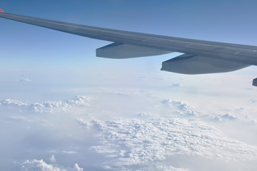 plane wing and cloud floating on sky through window frame